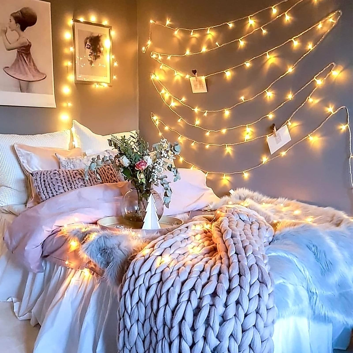 Warm white 100 LED battery string lights draped over a cozy bedroom wall