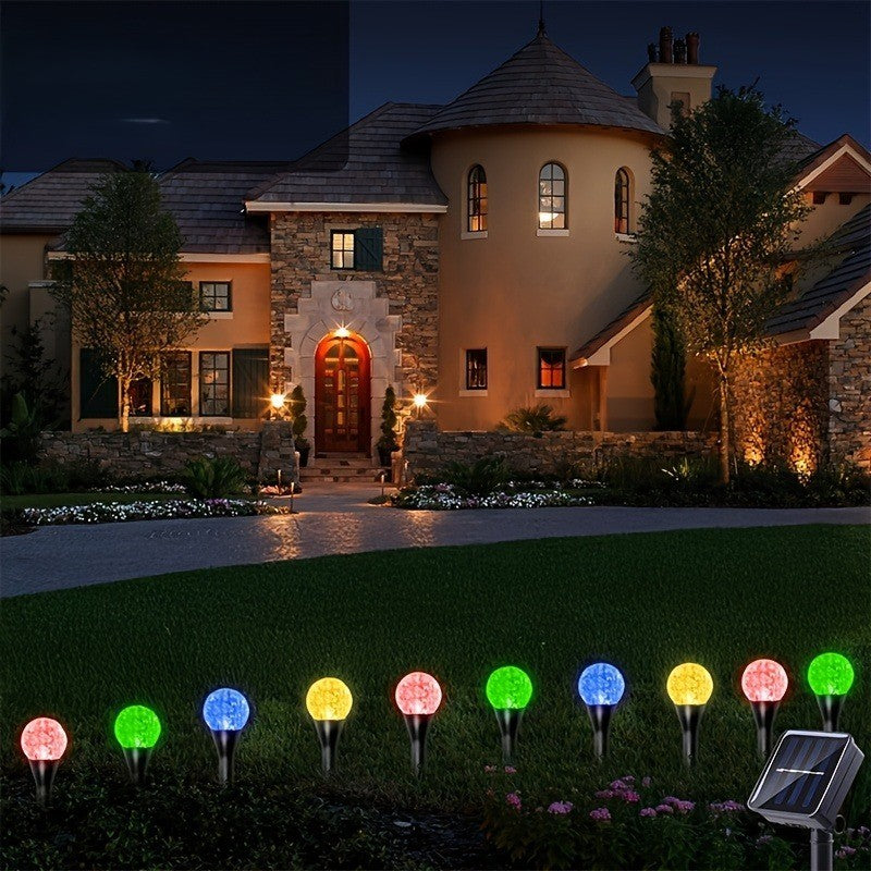 Multicolor solar crystal bubble ball garden stake lights along a villa lawn at night