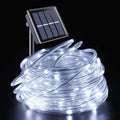 Cool White solar rope lights coiled with solar panel on black background