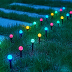 Multicolor solar crystal bubble ball stake lights glowing along garden pathway at dusk
