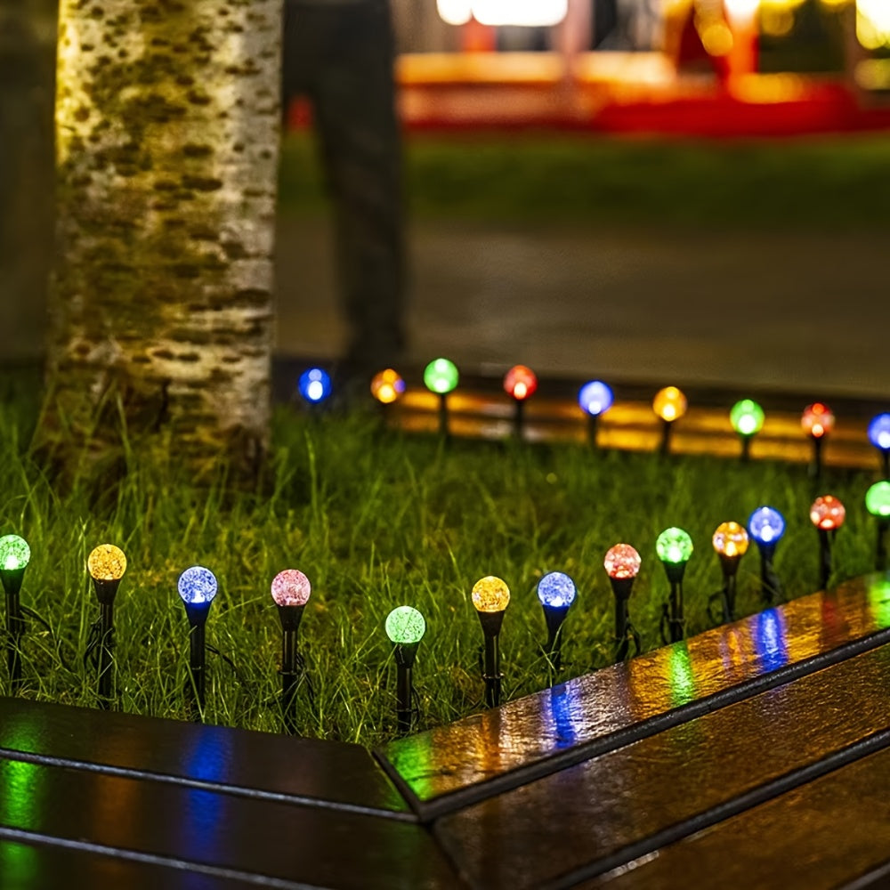 Warm white solar stake lights glowing in evening garden