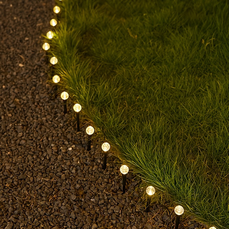 Warm white solar bubble ball lights on lawn at night